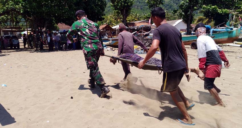 Pokmas dan Penjaga Pantai Rajegwesi saat mengevakuasi korban terseret arus pantai Teluk Ijo, Kecamatan Pesanggaran. (ist)