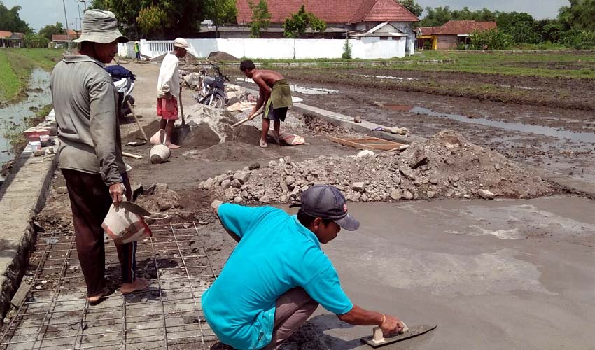 Warga mengeraskan ujung jalan Dusun Kramat dengan pengecoran . (par)