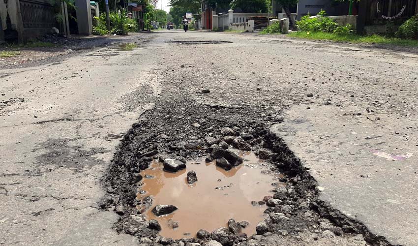 BERLUBANG - Kondisi JL Raya Desa Singogalih, Kecamatan Tarik, Sidoarjo yang dipenuhi puluhan lubang mengangah dikeluhkan warga dan pengguna jalan, Rabu (05/02/2020)