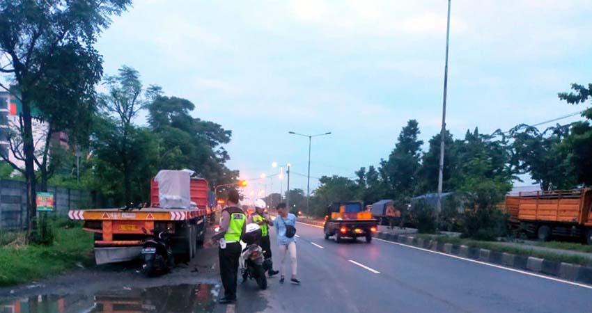 EVAKUASI - Petugas Unit Lantas Polsek Balongbendo menggelar olah TKP di jalur by pass Balongbendo seusai motor tabrak truk kontainer parkir, Minggu (9/2/2020)