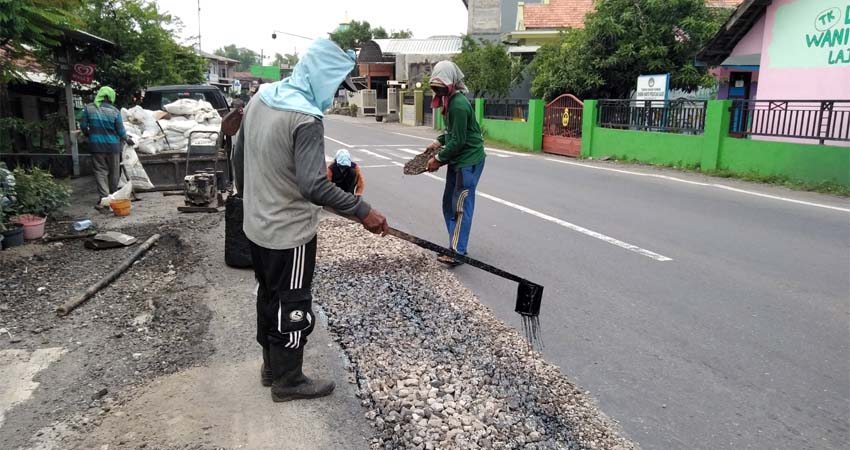 DIPERBAIKI : Dinas PU Bina Marga Sidoarjo, melakukan perbaikan jalan aspal di jalan raya Desa Lajuk (gus)