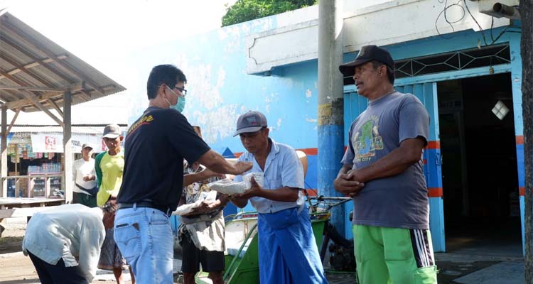 TAMPAK SENANG : Para tukang becak saat menerima paket beras, uang tunai dan masker dari pihak PT Salem Landangan Situbondo. (im)