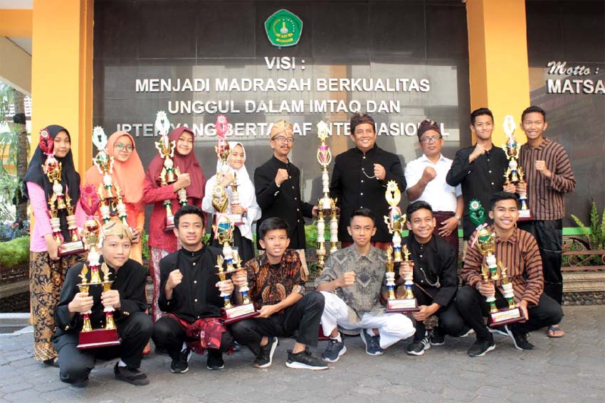 Samsudin, diapit para siswa-siswi MTsN 1 Kota Malang, yang sukses memboyong 21 medali di ToC Amerika Serikat, akhir tahun lalu. (adn)