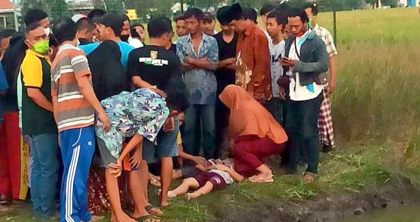 TENGGELAM - Warga berusaha menolong dua korban tenggelam, Satria Rizki (7) warga Desa Candi dan Celvin Dwi Saputra (7) warga Desa Sugiwaras, Kecamatan Candi, Sidoarjo yang mengapung di tengah kolam milik warga setempat, Rabu (13/5/20) petang