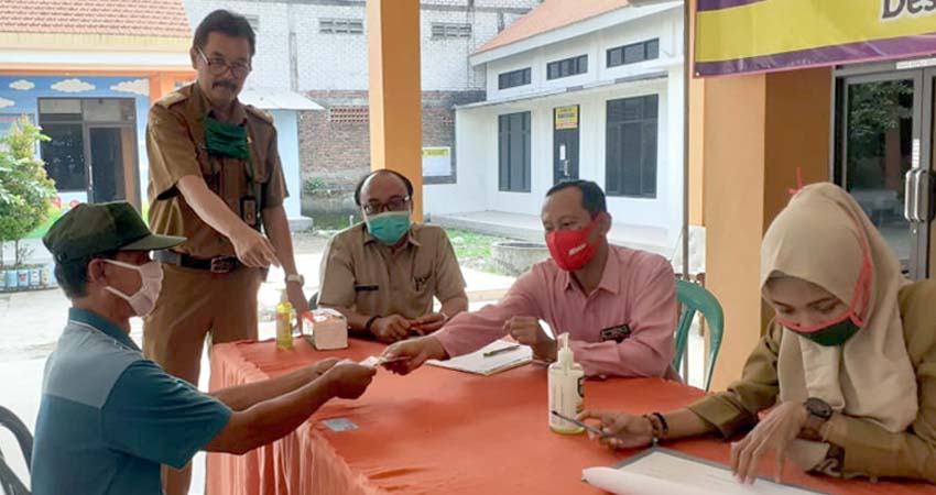 Pj. Kepala Desa Kajartengguli ( berdiri ) memantau pembagian BLT DD