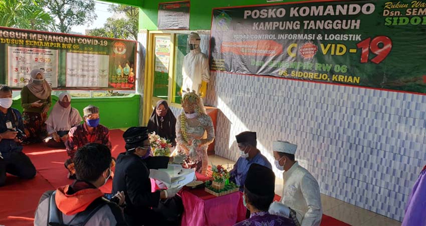 MENIKAH - Prosesi akad nikah mempelai Agus Triana dan Umi Nadziroh berlangsung di Posko Kampung Tangguh RW 06 Dusun Semampir, Desa Sidorejo, Kecamatan Krian, Sidoarjo, Jumat (6/6/2020)