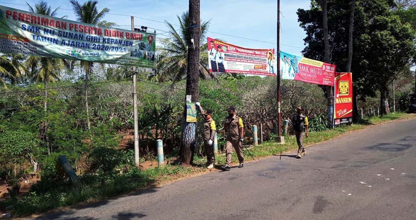 Petugas Satpol PP saat melakukan penertiban, pembersihan dan pembongkaran reklame tak berijin. (Ist)