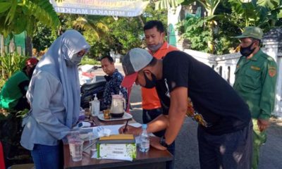 Tim relawan Desa Lemujut mengawasi pengguna jalan sedang mengisi form identitas di pos check point (gus)