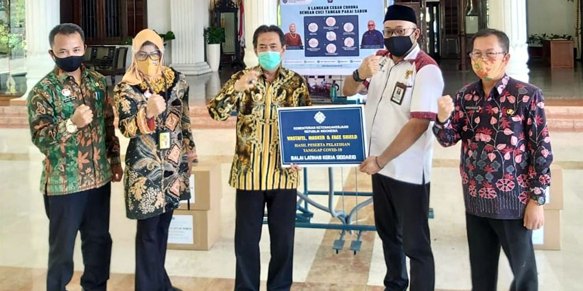 PENYERAHAN - Kepala BLK Sidoarjo Imam Agung menyerahkan bantuan kepada Plt Bupati Sidoarjo, Nur Ahmad Syaifuddin yang juga Ketua Gugus Tugas Percepatan Penanganan Covid-19 Sidoarjo di pendopo Delta Wibawa, Selasa (21/7/2020)