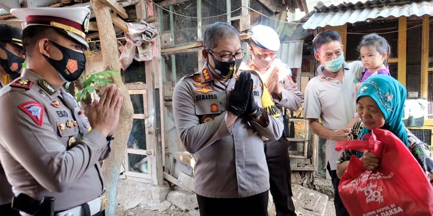 SERAHKAN BANTUAN - Kapolresta Sidoarjo Kombes Pol Sumardji turun langsung secara door to door ke rumah warga menyerahkan bantuan ke warga Desa Cemengkalang, Kecamatan Sidoarjo, Selasa (28/7/2020)