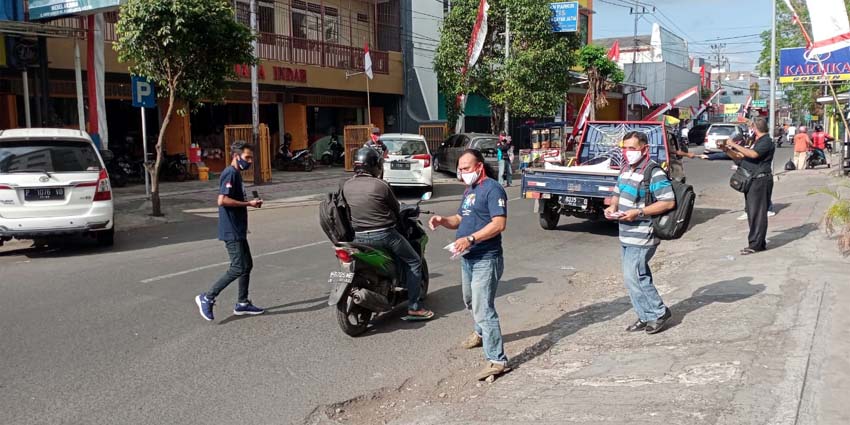 BAGIKAN MARKER: Jurnalis yang tergabung dalam FWLM Jember membagikan masker kepada para pengendara