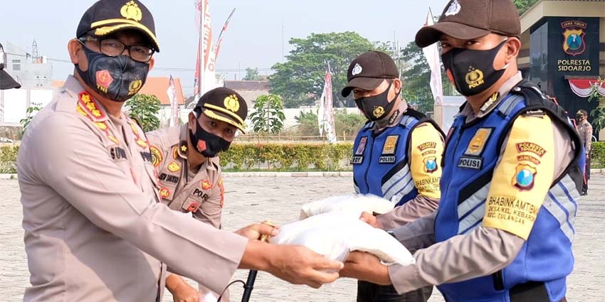 DISTRIBUSIKAN - Kapolresta Sidoarjo, Kombes Pol Sumardji mendistribusikan 10 ton beras yang dibagikan 349 Bhabinkamtibmas, 9.000 masker dibagikan 18 polsek jajaran, APD baju hazmat 440 unit dan face shield 440 unit, Kamis (06/08/2020)