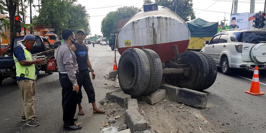 EVAKUASI - Sejumlah anggota Lantas Polsek Balongbendo menggelar olah TKP Truk Tangki yang patah di perempatan Pos Polisi JL Raya Surabaya-Mojokerto, Desa Bakalan, Kecamatan Balongbendo, Sidoarjo, Selasa (11/08/2020) sore