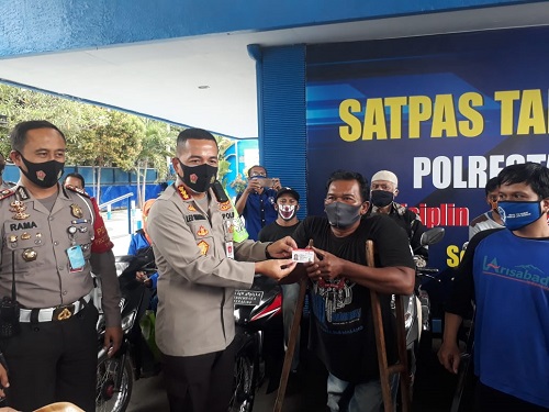 Kapolresta Malang Kota Kombes Pol Dr Leonardus dan Kasat Lantas AKP Ramadhan membagikan masker dan sembako. (gie)