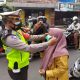 Petugas memasangkan masker kepada ibu-ibu yang ditemui di jalan. (ist)