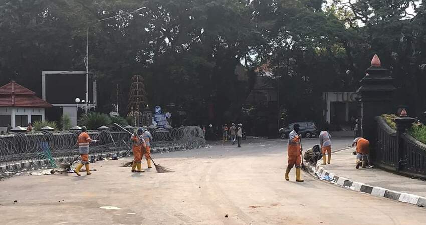 Petugas kebersihan DLH Kota Malang melakukan pembersihan belas-bekas aksi unjuk rasa.