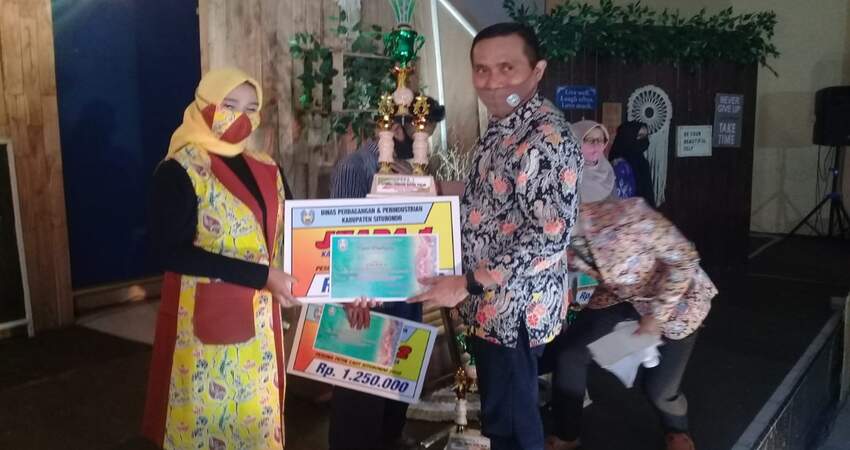 Kepala Dinas Perdagangan dan Perindustrian Kabupaten Situbondo Abdul Kadir Jaelani S Sos M Si saat memberikan hadiah kepada Juara 1 lomba kegiatan Batik Situbondo New Normal Fashion. (her)