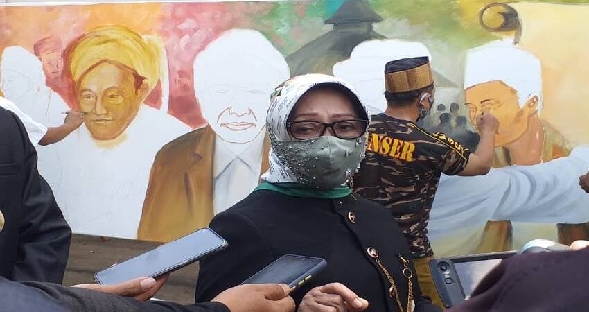 Bupati Jombang, Hj. Mundjidah Wahab berlatar lukisan Jombang dengan tema 'Resolusi Jihad'.