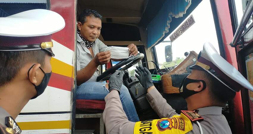 Kasat Lantas Polresta Malang Kota AKP Ramadhan Nasution SH SIK saat membagikan masker ke sopir bus. (ist)