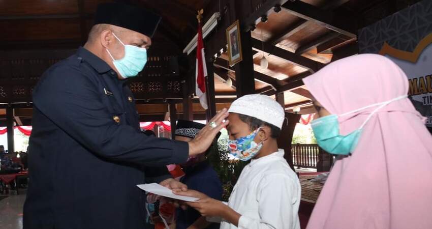 Pjs Bupati Malang, Drs Sjaichul Ghulam MM, memberikan santunan kepada anak yatim.
