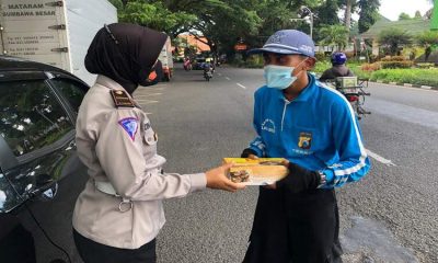 Sat Lantas Polresta Malang Kota bagikan nasi kotak dan masker saat sosialisasi Prokes. (ist)