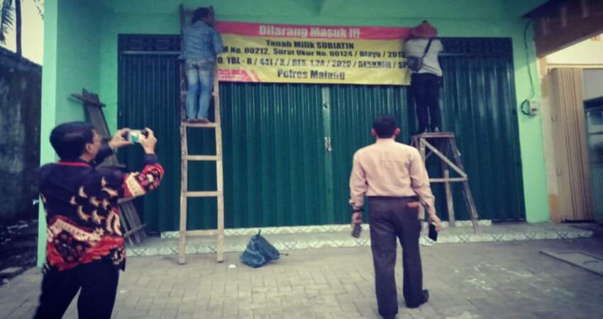 Pemasangan banner peringatan dilarang masuk di Kantor Bank Kanindo.