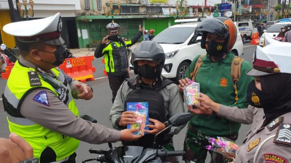 Petugas Polresta Malang Kota Berikan Hadiah Coklat Bagi Pengendara Taat Prokes dan Disiplin Berlalu Lintas